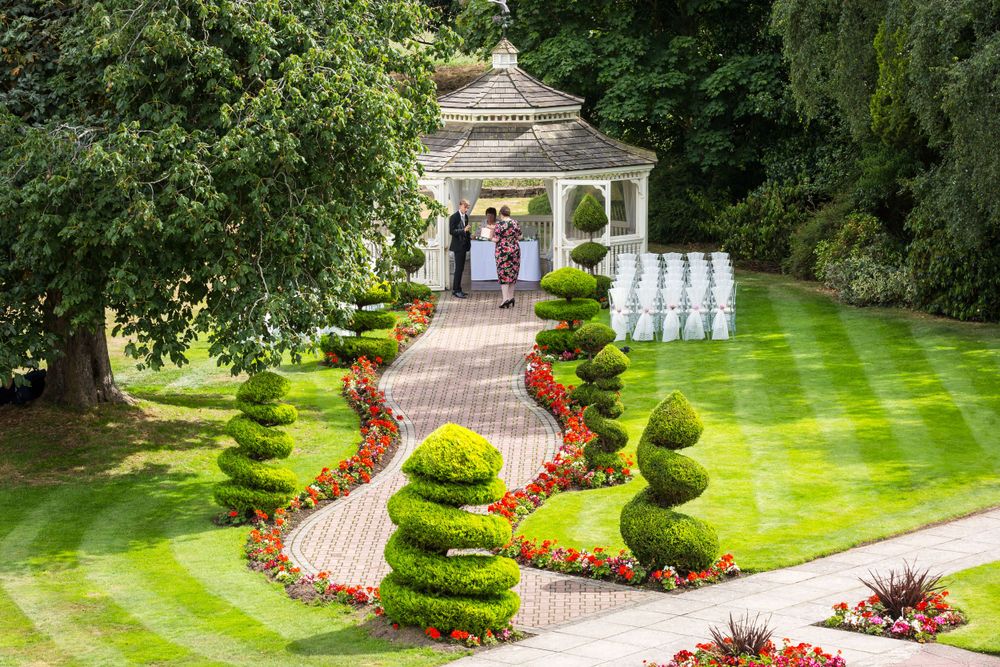 An aerial view of a wedding ceremony in a garden.