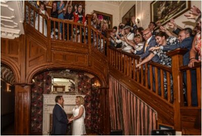 Wedding ceremony with guests on staircase.