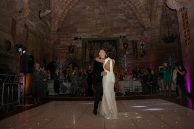 Bride and groom first dance in elegant castle hall.