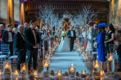 Winter-themed wedding aisle with bride, groom, and guests.