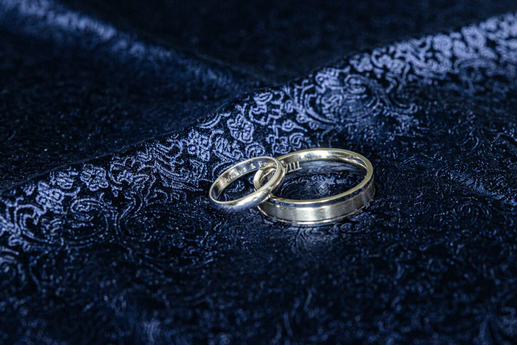 Wedding rings on dark lace fabric.