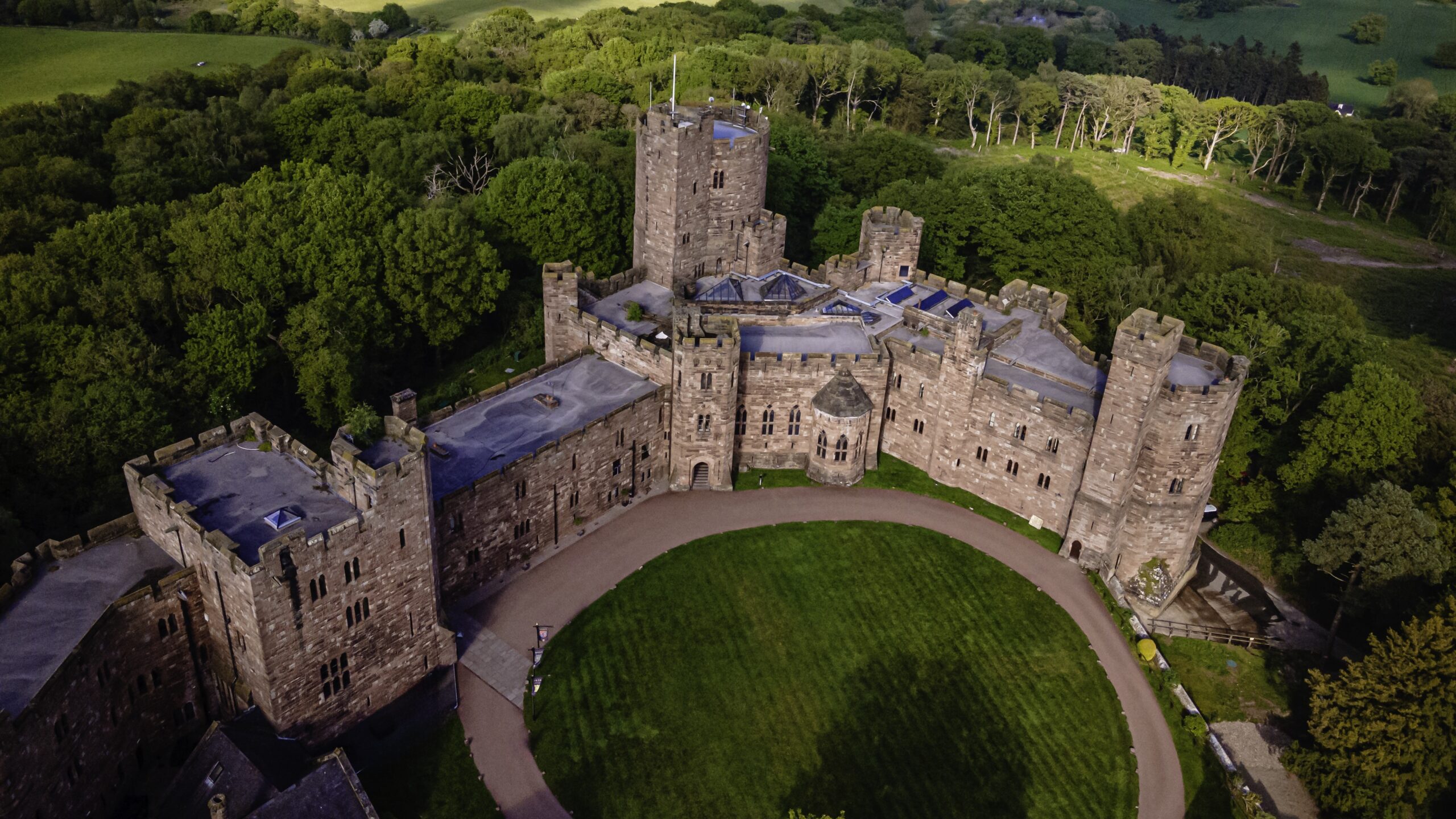 Aerial view of historic medieval Peckforton castle at dusk.