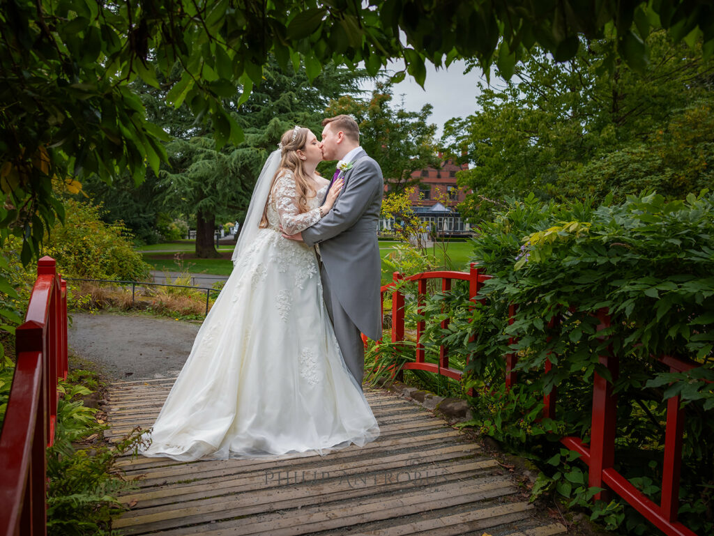 Bride and groom kissing on bridge in Chester Zoo Wedding venue