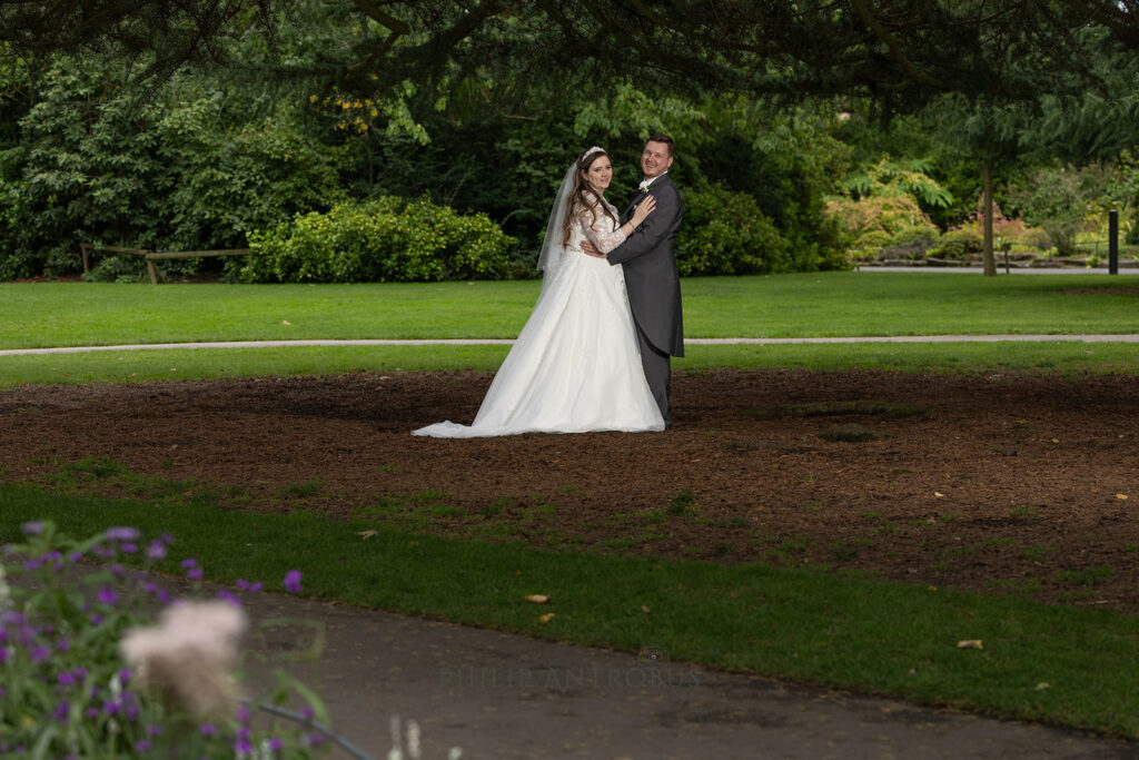 Bride and groom posing in gardens at wedding venue in Chester