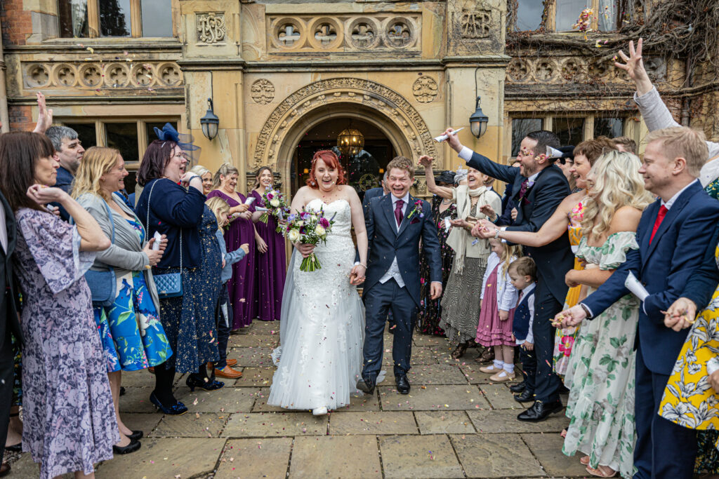 Bride and groom joyful confetti walk with guests