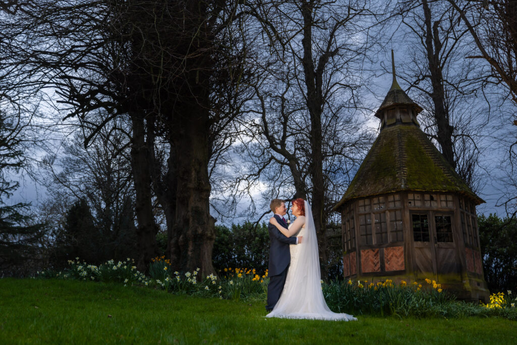 Couple embracing by gazebo at North Wales wedding