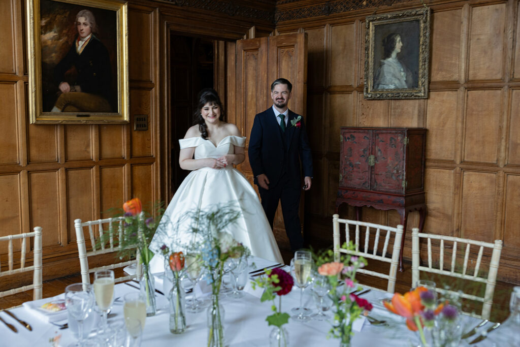 Bride and groom entering decorated room.
