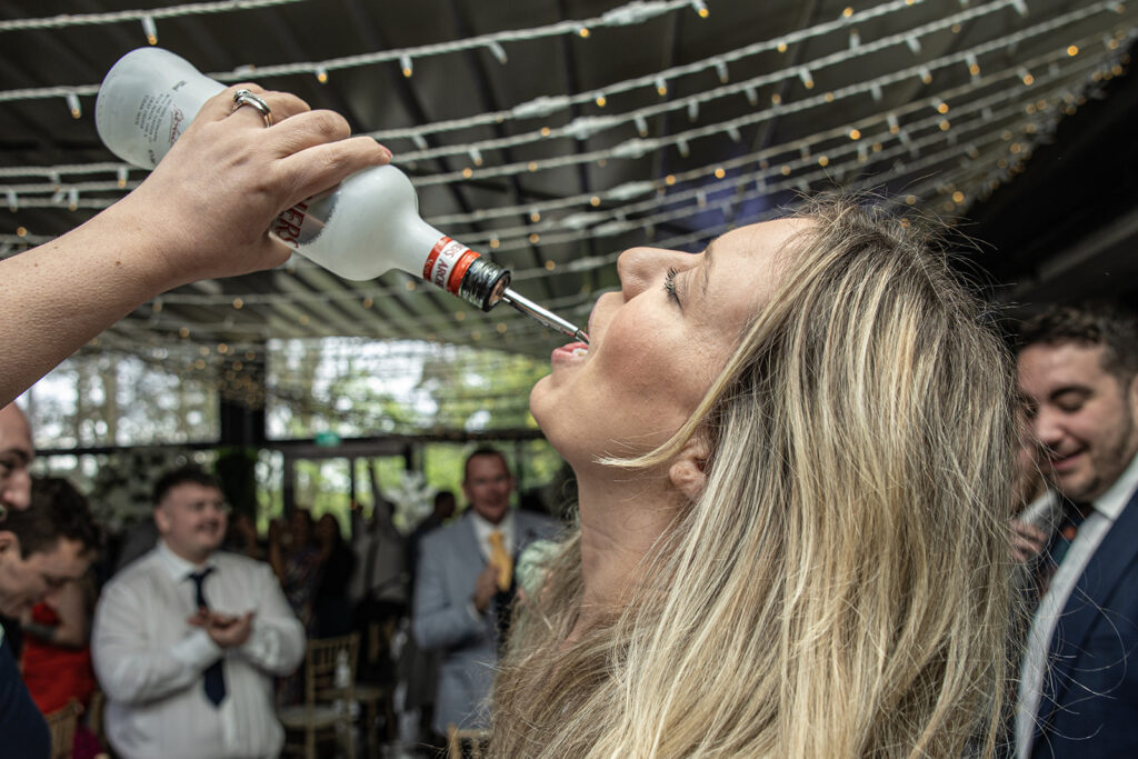 Person drinking from a bottle at a party