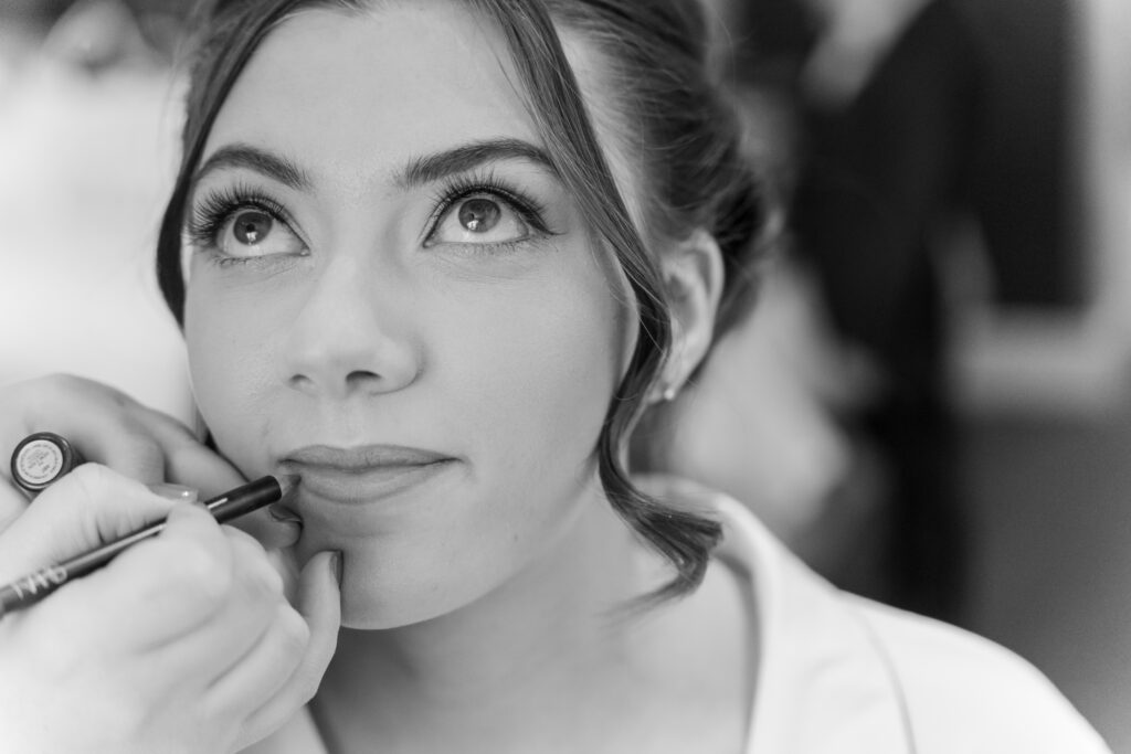 Woman having her lips outlined with makeup pencil