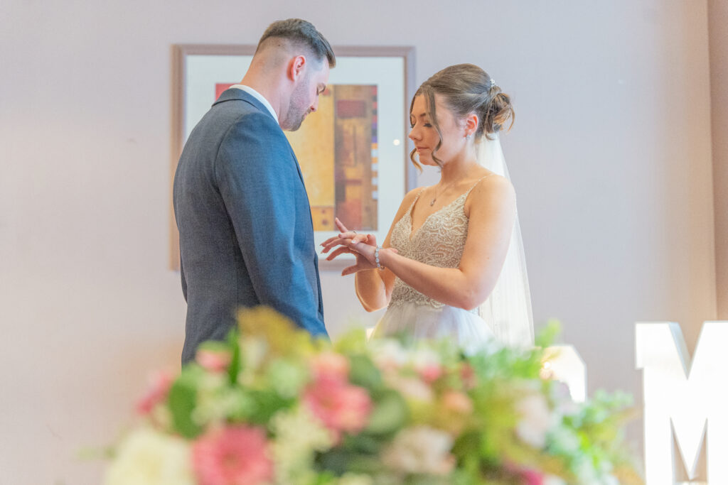 Bride and groom exchanging rings at wedding ceremony.