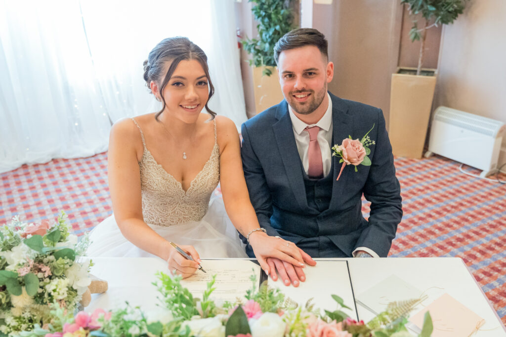 Bride and groom signing marriage register