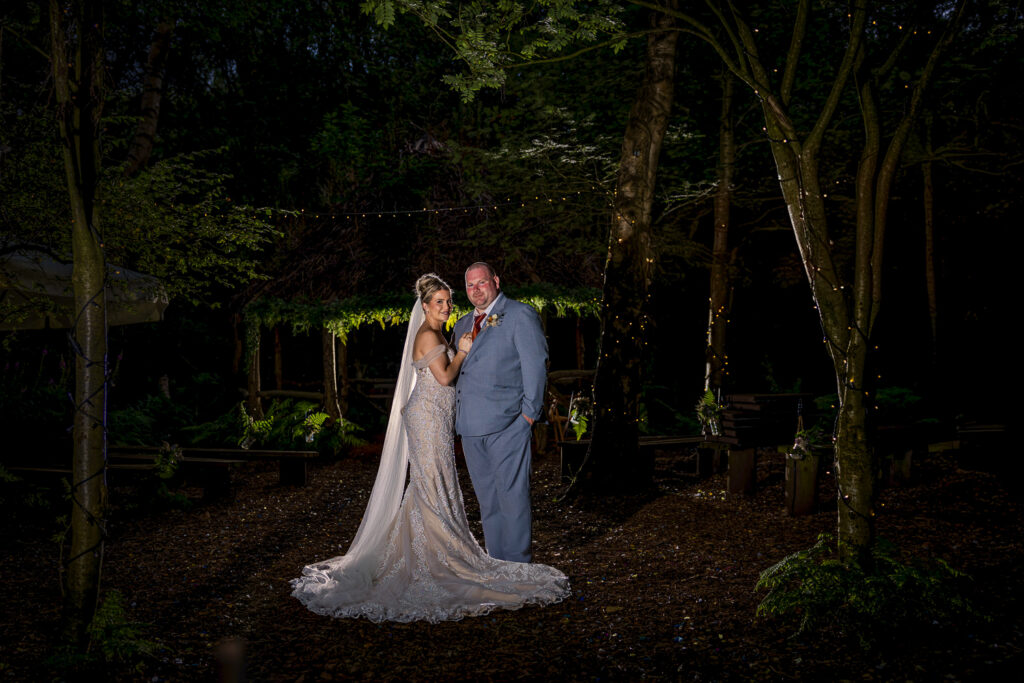Bride and groom in enchanted forest setting.