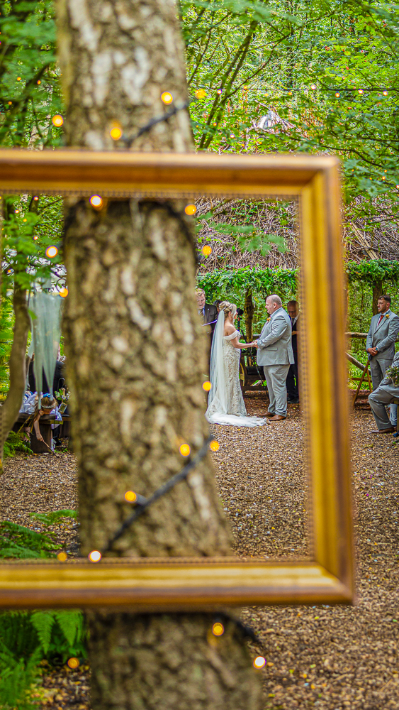 A bride and groom stand at a forest ceremony, beautifully captured by a Cheshire Woodland Wedding photographer Philip Antrobus