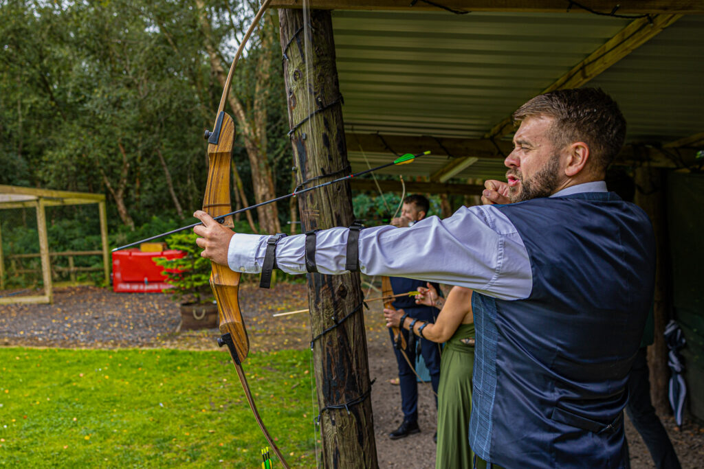 Man practicing archery in outdoor setting Cheshire Woodland Wedding