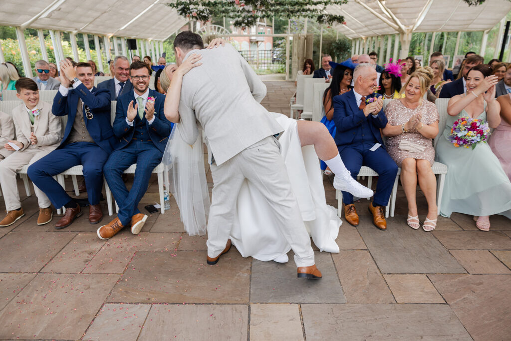 Groom dips bride as he kisses her at Cheshire Wedding Venue