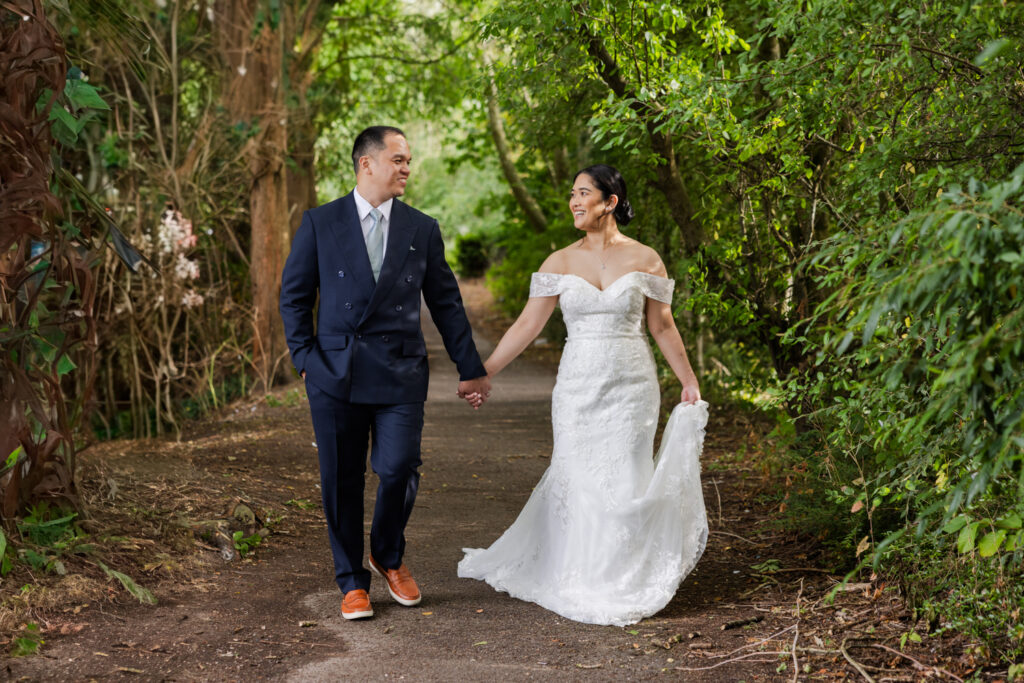 Couple walking in forest, bride in wedding dress.
