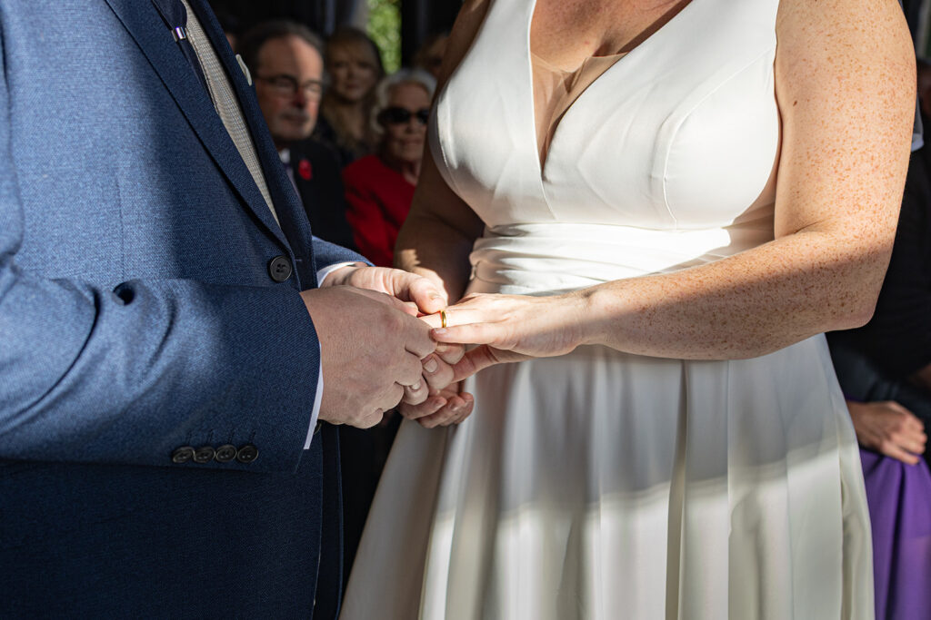 Couple exchanging wedding rings in ceremony.