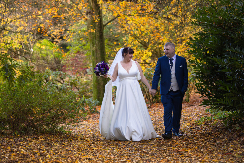 Bride and groom walking in autumn forest