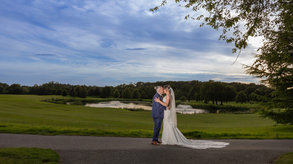 Wedding couple kissing in gardens at Carden Park Wedding by Philip Antrobus Photography