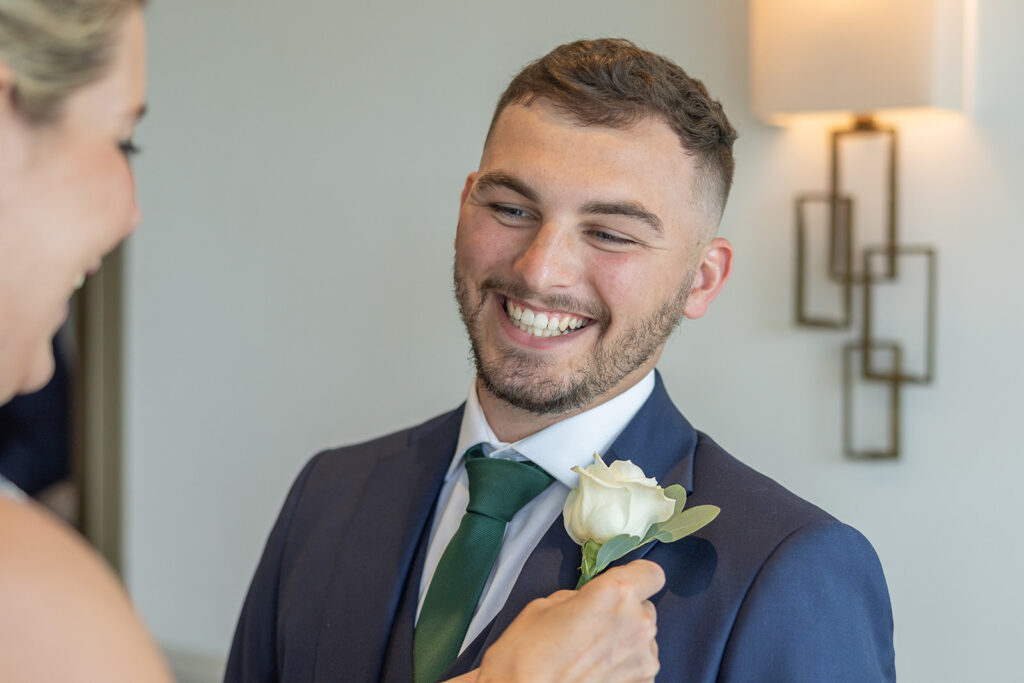 Best man having his buttonhole pinned to his jacket at Chester Wedding Venue
