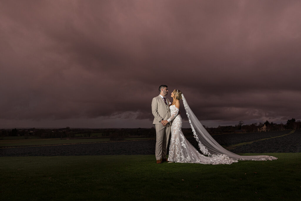 Bride and groom under dramatic sunset sky at West Tower photography by Philip Antrobus Photography
