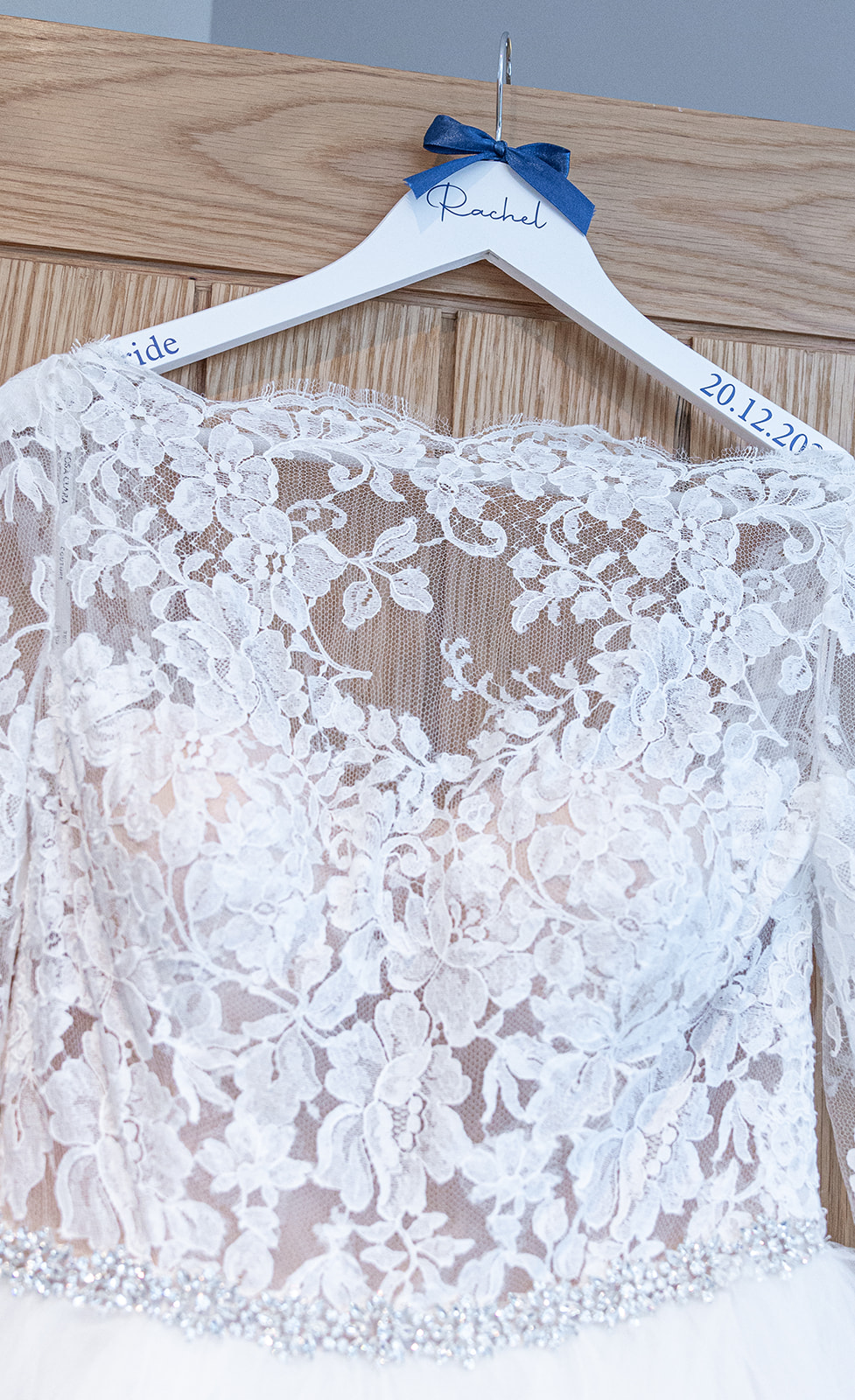 Lace wedding dress hanging on personalised hanger.
