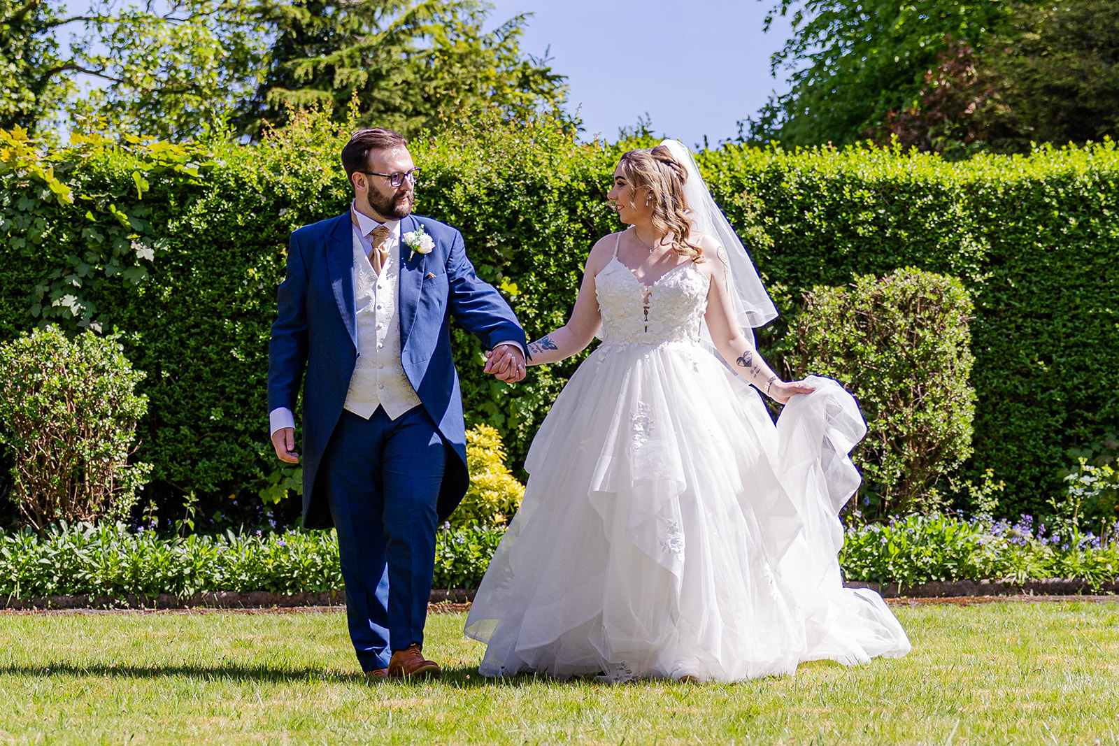 Bride and groom walking hand in hand outdoors. Liverpool Wedding Photography