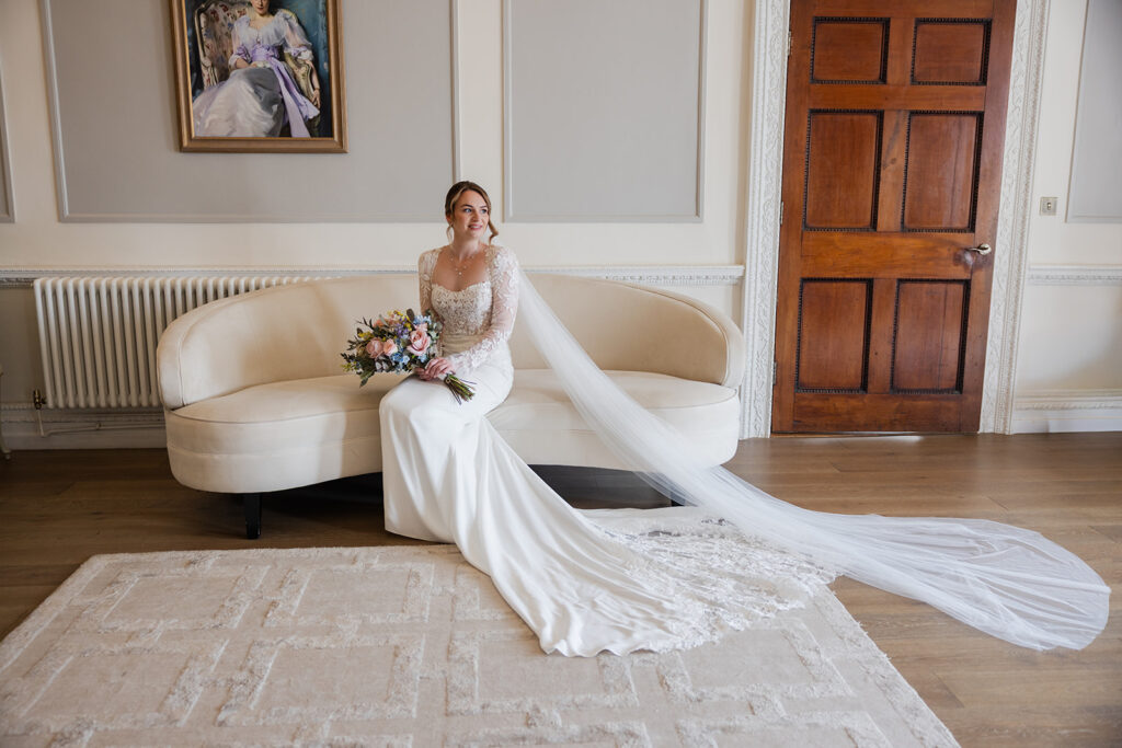 Bride in elegant gown sitting on sofa