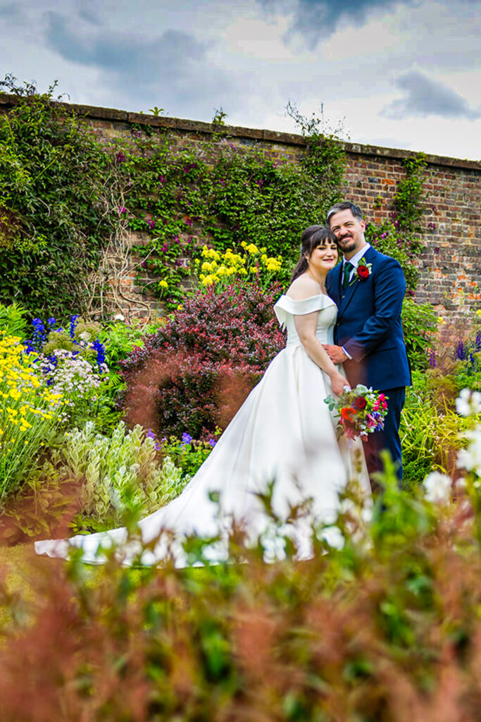 Bride and groom in colourful garden